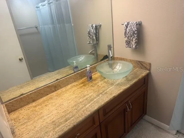 a bathroom with a granite countertop sink and a mirror