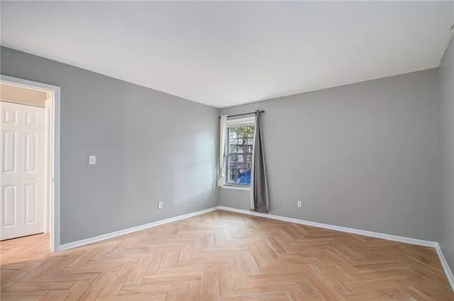 a view of an empty room with window and stairs