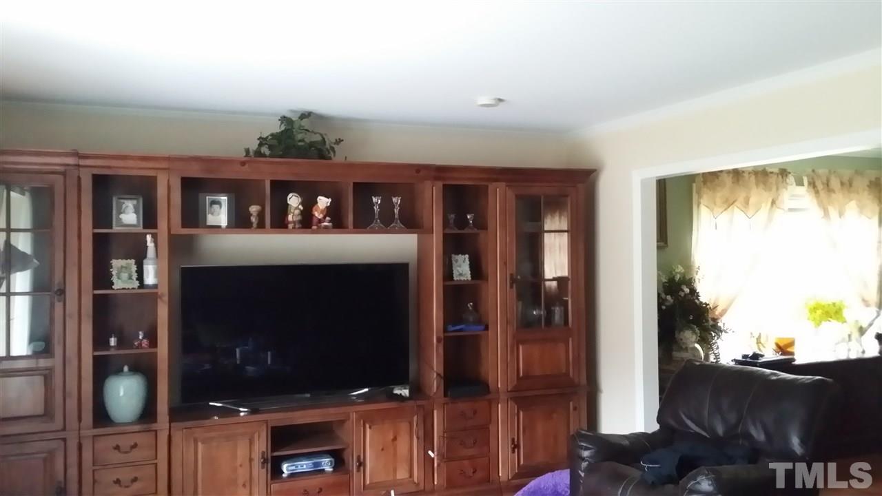 5404 Live Oak Trail Raleigh, NC 27613 - Photo 12 of 14 a living room with furniture a flat screen tv and a floor to ceiling window