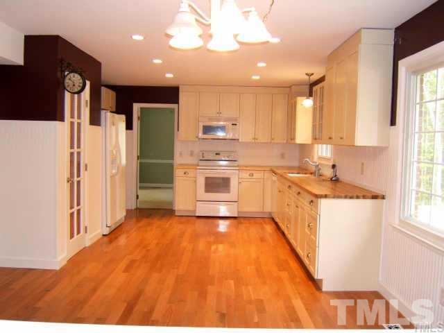 5404 Live Oak Trail Raleigh, NC 27613 - Photo 13 of 14 a kitchen with stainless steel appliances granite countertop a refrigerator a sink dishwasher a stove and white countertops with wooden floor