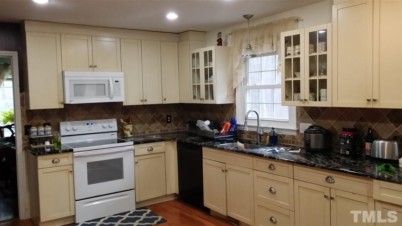 5404 Live Oak Trail Raleigh, NC 27613 - Photo 10 of 14 a kitchen with granite countertop white cabinets and stainless steel appliances