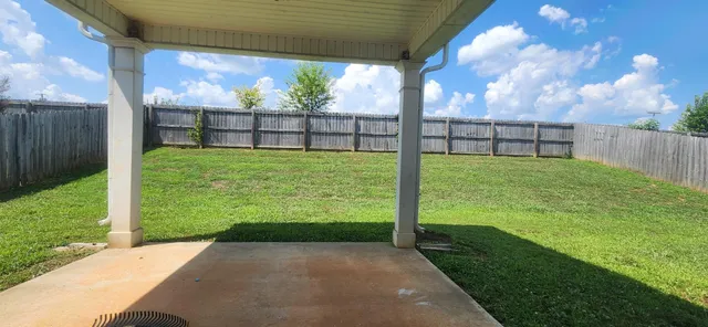 a view of a back yard with a wooden fence