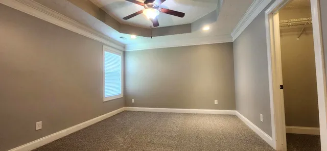 an empty room with windows and fan