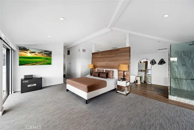 a bedroom with a bed and a flat tv screen on dresser