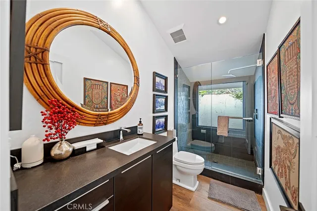 a bathroom with a sink a mirror a toilet and a shower