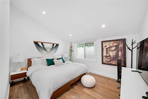 a bedroom with bed and a painting on the wall