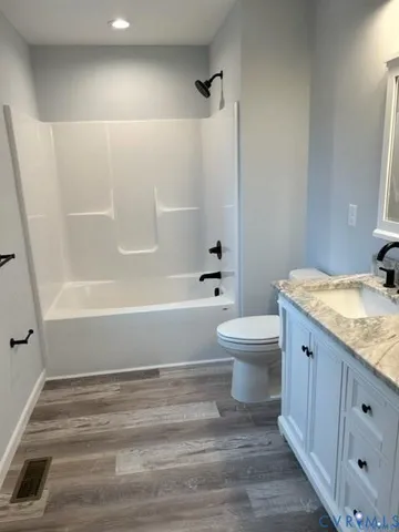 a bathroom with a granite countertop toilet a sink and a bathtub