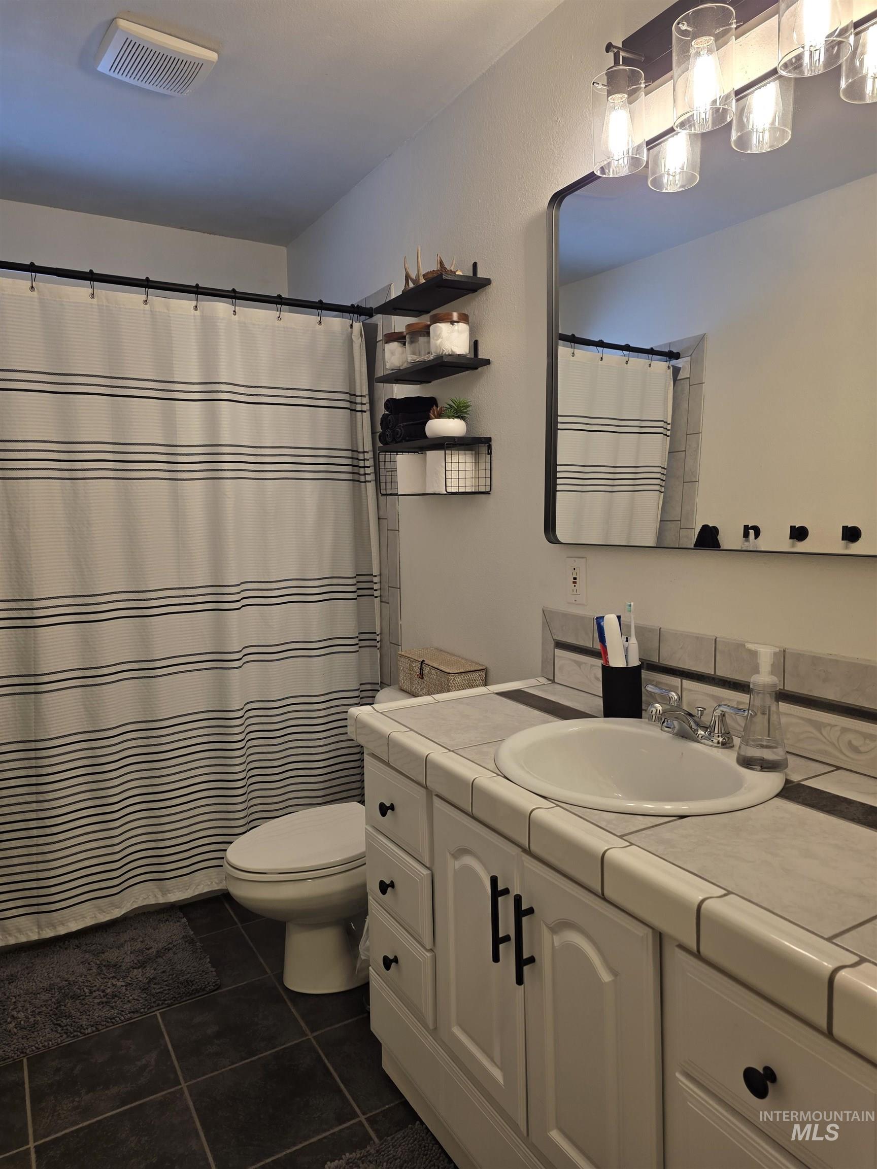 179 Timberline Drive Pierce, ID 83546 - Photo 20 of 24 Bathroom featuring vanity, a shower with shower curtain, and dark tile patterned floors