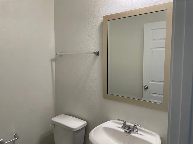 a bathroom with a sink a toilet and a mirror