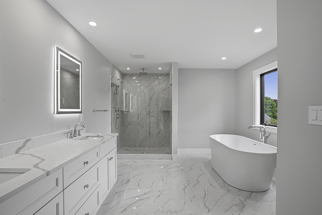 18 Avon Circle Needham, MA 02494 - Photo 13 of 18 a bathroom with a double vanity sink a mirror and a bathtub