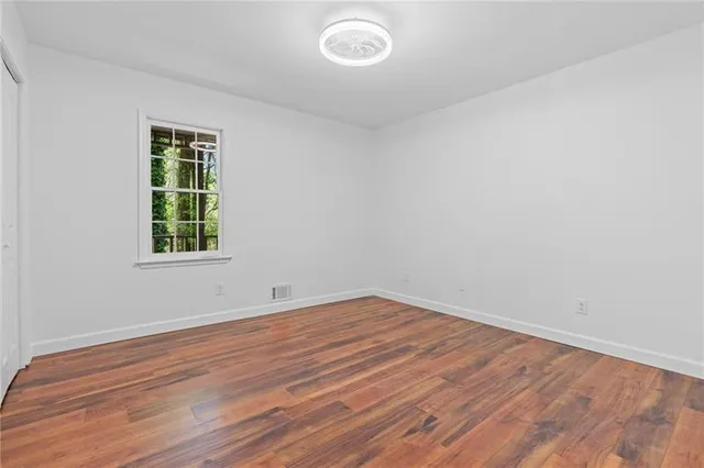 wooden floor in an empty room with a window