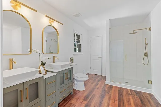 a bathroom with a double vanity sink toilet and shower