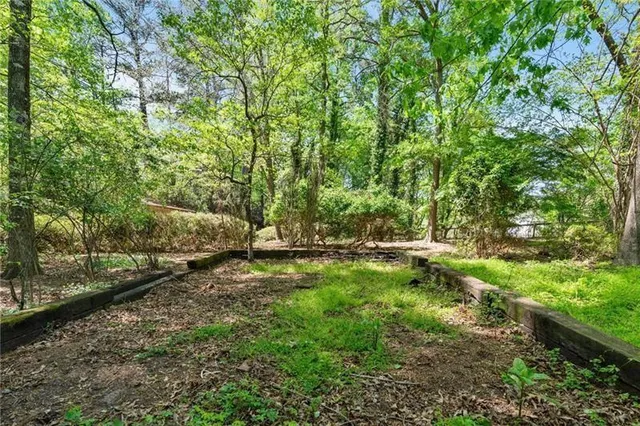 an aerial view of residential house with outdoor space and trees all around
