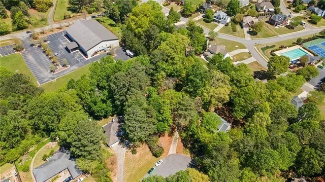an aerial view of residential house with outdoor space and trees all around