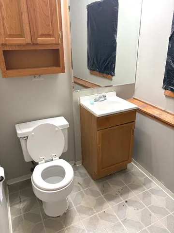 a bathroom with a toilet a sink and a mirror