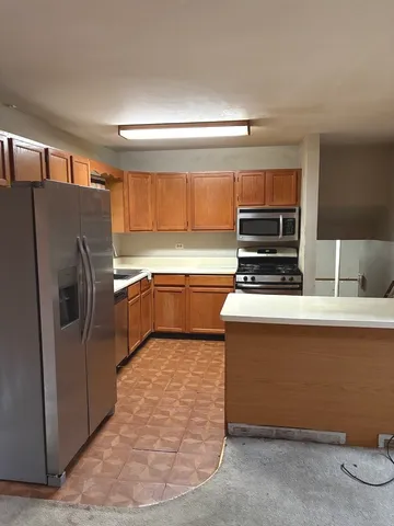 a kitchen with stainless steel appliances a stove a sink and a refrigerator