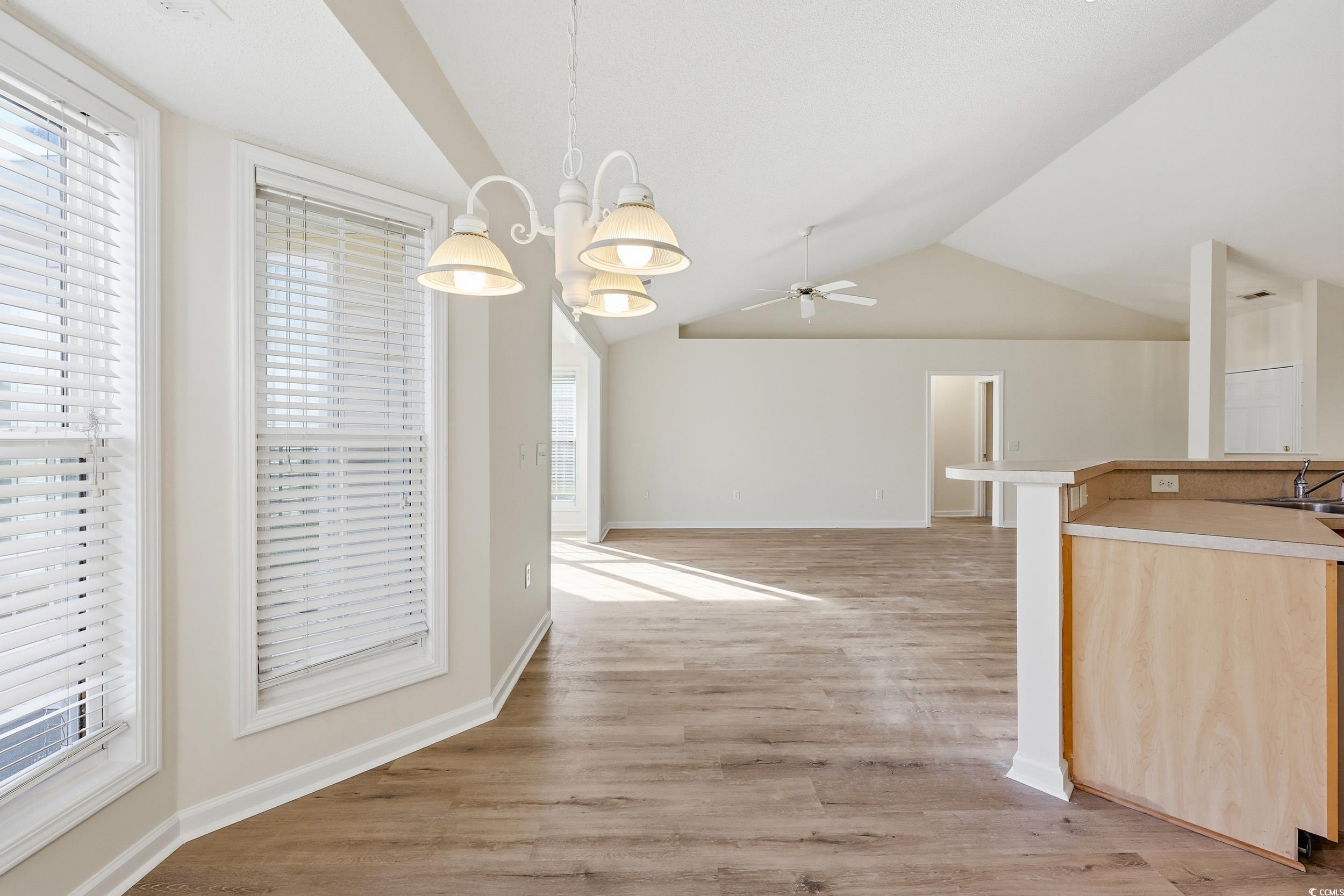 323 Chastain Court Murrells Inlet, SC 29576 - Photo 10 of 37 Unfurnished dining area featuring light wood finished floors, a textured ceiling, and a chandelier