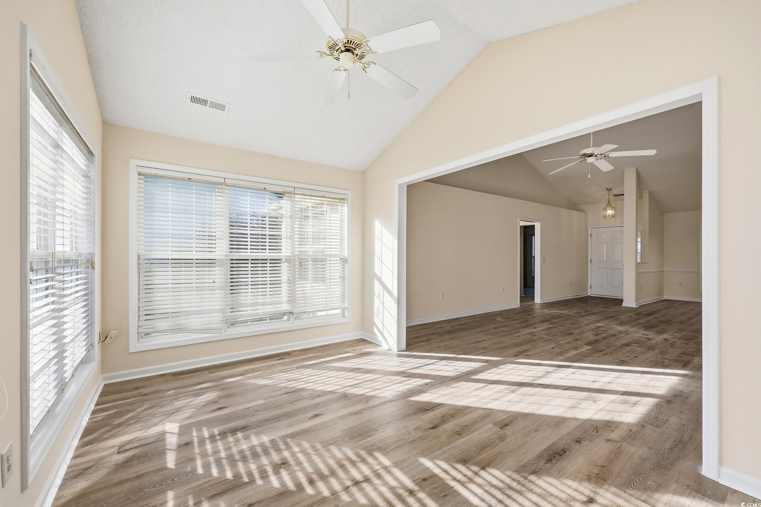 323 Chastain Court Murrells Inlet, SC 29576 - Photo 15 of 37 Unfurnished sunroom with lofted ceiling, wood finished floors, and a textured ceiling