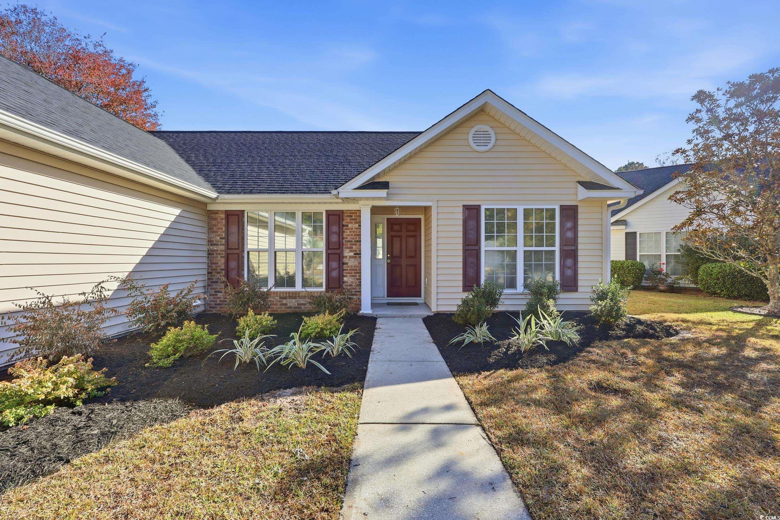 View of front of home featuring a front yard, brick siding, and roof with shingles