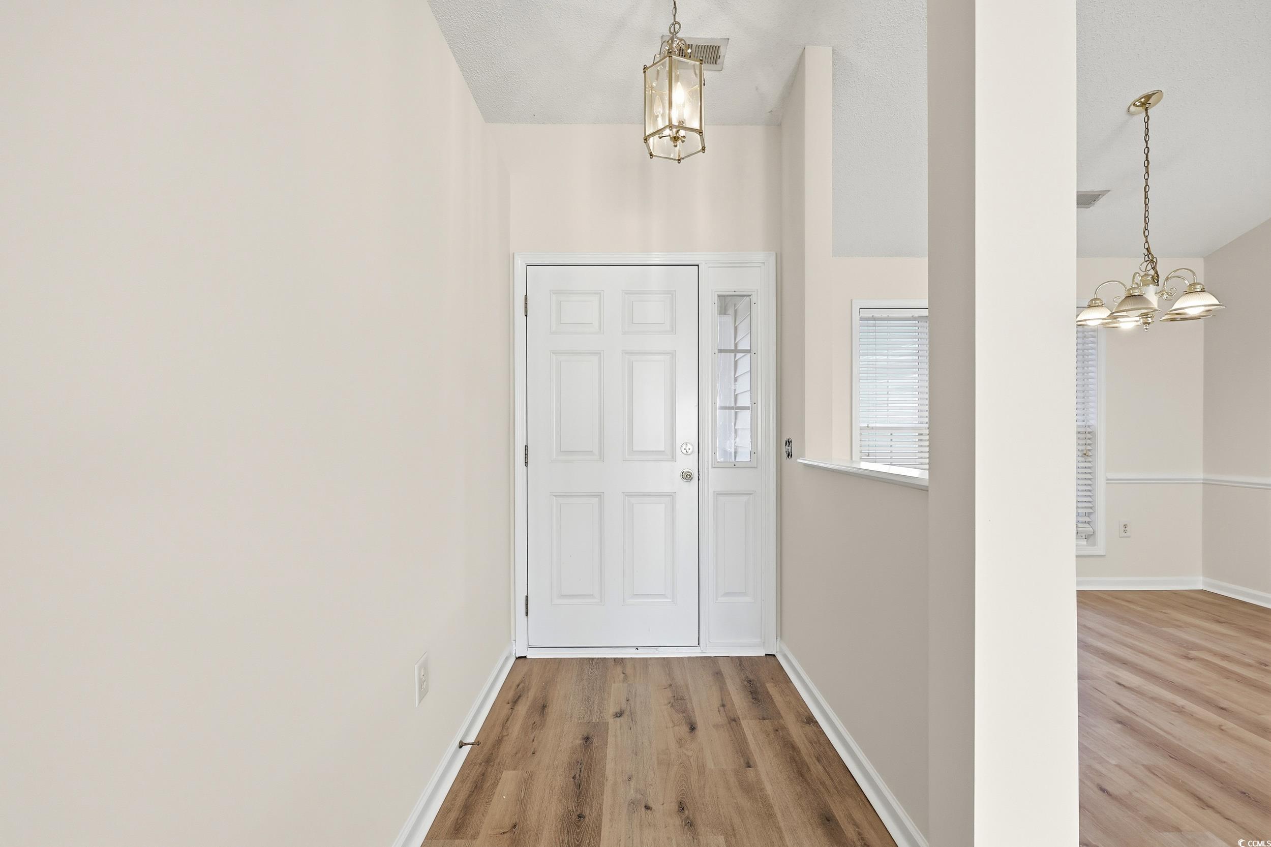 Foyer with a chandelier and light wood finished floors