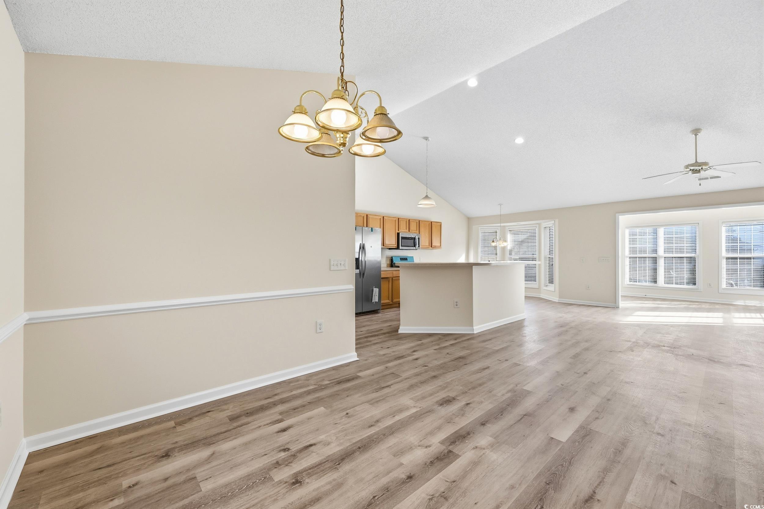 323 Chastain Court Murrells Inlet, SC 29576 - Photo 8 of 37 Unfurnished dining area featuring light wood-type flooring, a chandelier, and vaulted ceiling