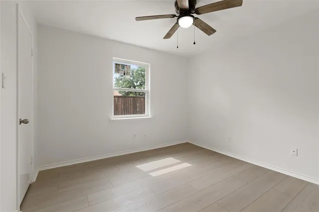 a view of an empty room with a fireplace and a window