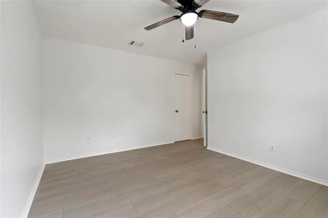 an empty room with a window and a fan