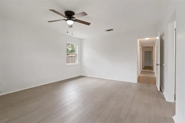 an empty room with closet and windows