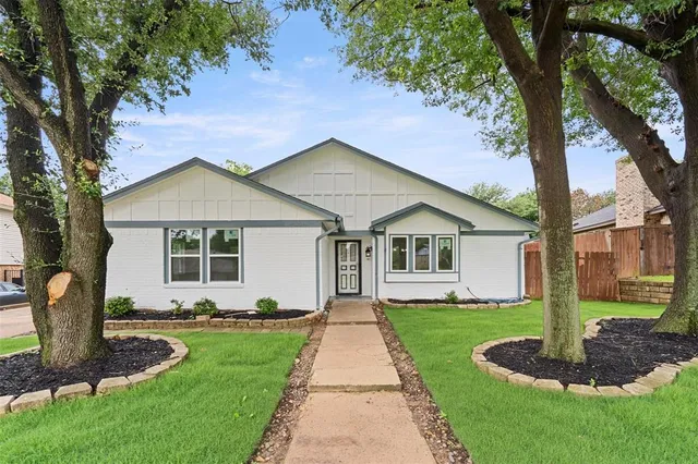 a front view of a house with a yard and trees