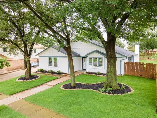 a front view of house with a garden and trees