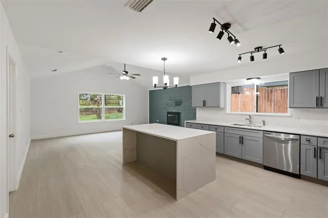 a large kitchen with kitchen island a sink a stove a dining table and chairs