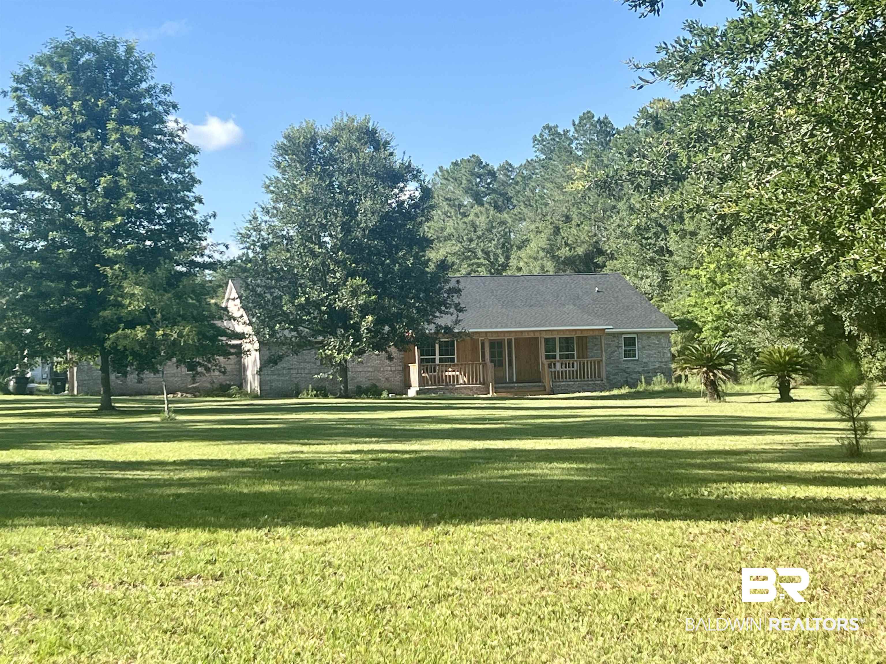 29685 Gardner Road Elberta, AL 36530 - Photo 1 of 16 Stone-clad residence featuring a covered front porch with wood columns and railings