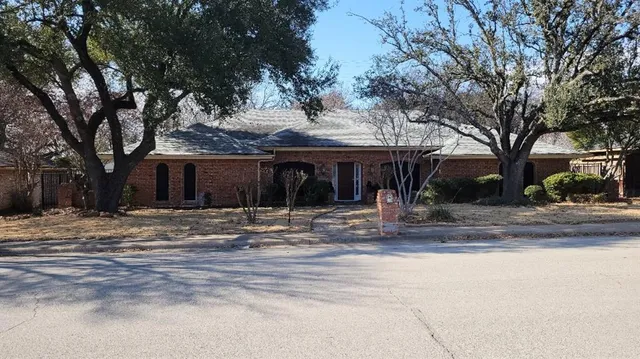 a view of a house with street that has a tree