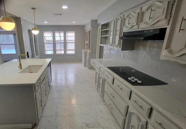 a kitchen with stainless steel appliances granite countertop a sink a stove and a refrigerator