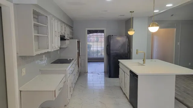 a kitchen that has a sink a stove and a refrigerator