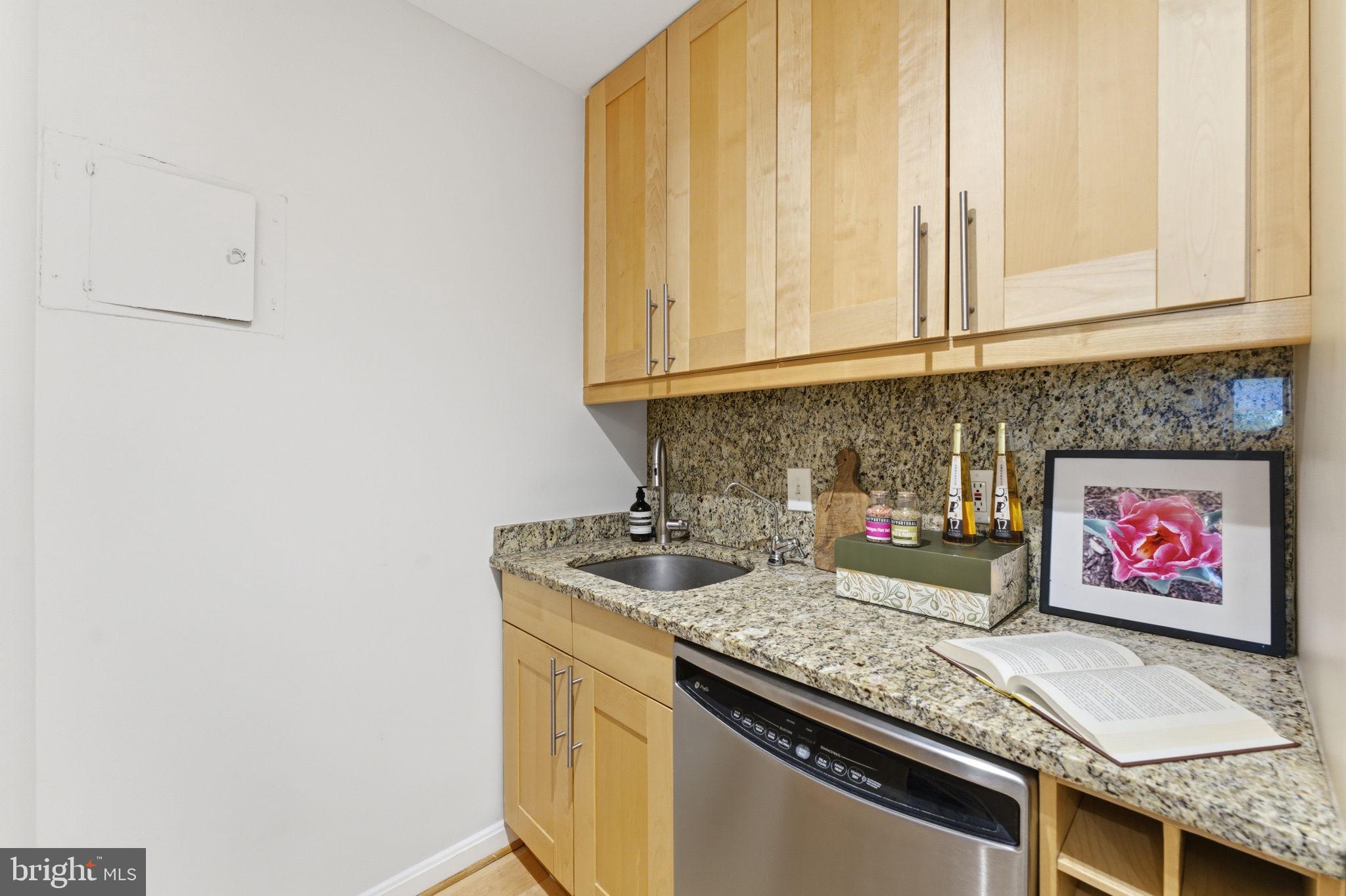 1435 4th Street Southwest, Unit B609 Washington, DC 20024 - Photo 20 of 52 a kitchen with stainless steel appliances granite countertop a sink and a white cabinets