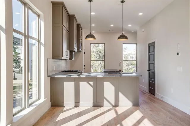 a kitchen with stainless steel appliances granite countertop a stove a sink and a refrigerator with wooden floor