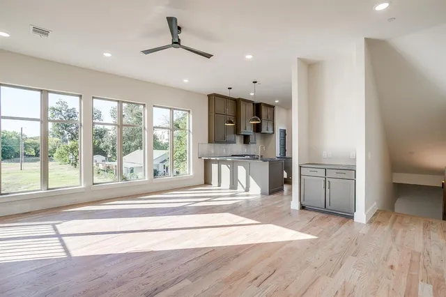 a view of a kitchen with a refrigerator and a stove top oven