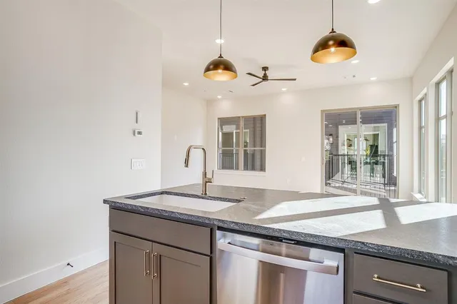 a kitchen with stainless steel appliances granite countertop a sink a stove and a refrigerator