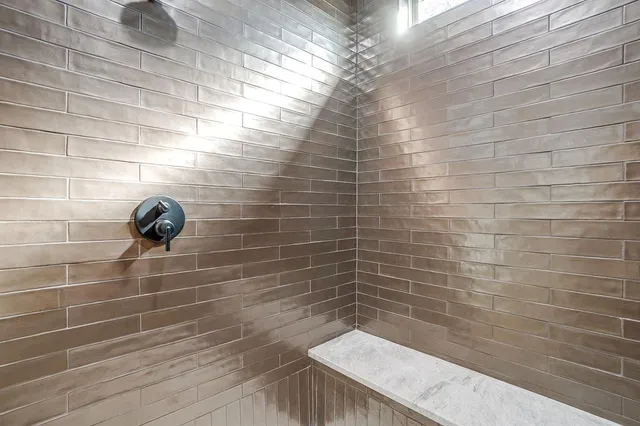 a view of a hallway with wooden floor and a bathroom