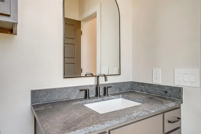 a bathroom with a granite countertop sink a toilet and bathtub