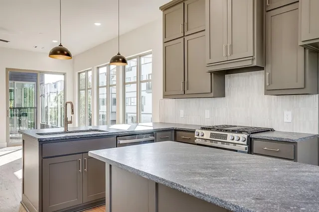 a kitchen with stainless steel appliances granite countertop a sink a stove and a microwave