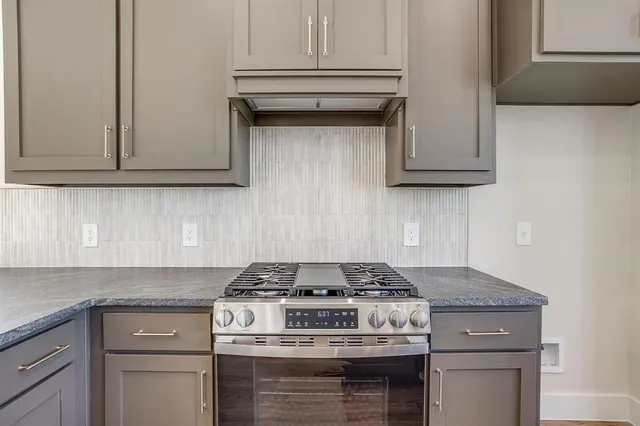 a stove top oven sitting inside of a kitchen and granite counter tops