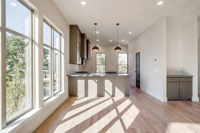 a kitchen with stainless steel appliances granite countertop a sink a stove and a microwave