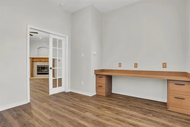 a view of an empty room with wooden floor and cabinet