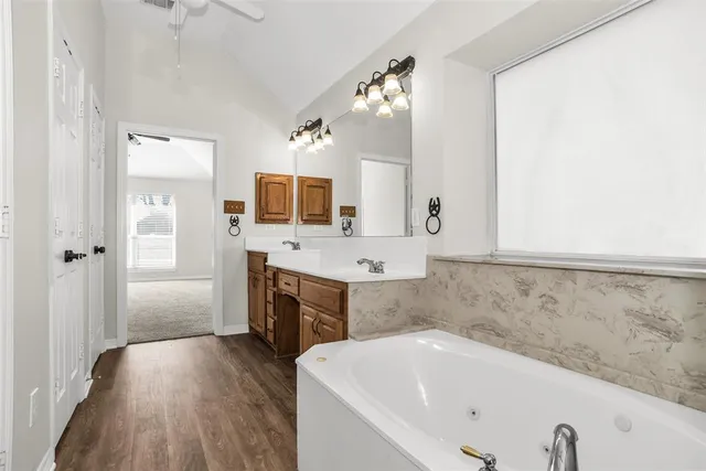 a bathroom with a tub sink and mirror