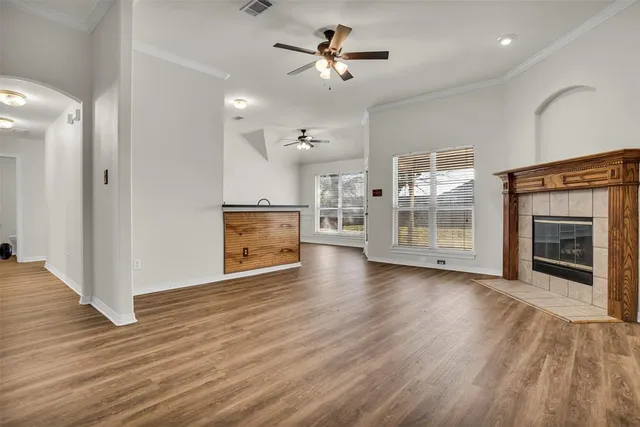 wooden floor fireplace and windows in an empty room