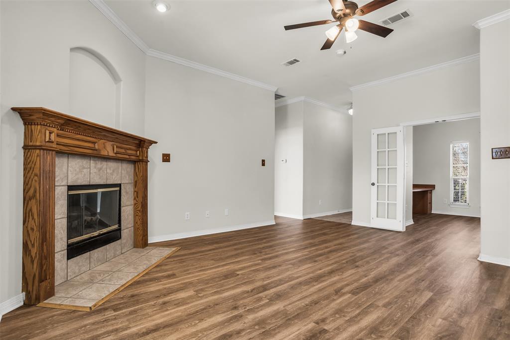 233 Cobblestone Circle Red Oak, TX 75154 - Photo 5 of 23 a view of an empty room with wooden floor and a fireplace