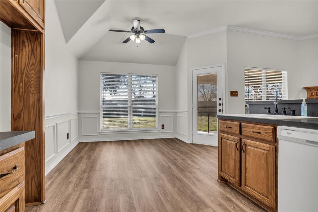 233 Cobblestone Circle Red Oak, TX 75154 - Photo 6 of 23 a view of an empty room with a kitchen and wooden floor