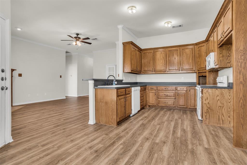 233 Cobblestone Circle Red Oak, TX 75154 - Photo 8 of 23 a kitchen with stainless steel appliances granite countertop a stove top oven a sink and white cabinets with wooden floor